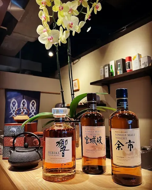 Sake lining on a stand, right next to the sushi bar